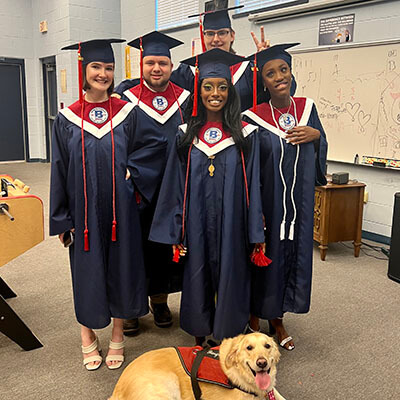 Broach School Orange Park Students in Cap & Gown with a Service Dog